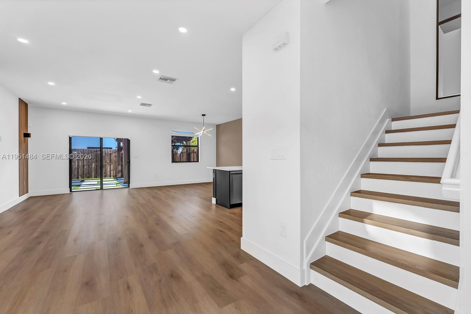 13067 Southwest 286th Street, Unit 13067 Homestead, FL 33033 - Photo 2 of 37 a view of an empty room with wooden floor and stairs