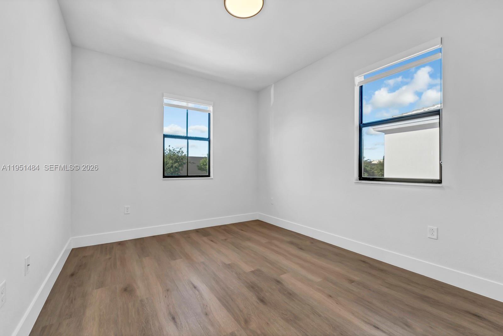 13067 Southwest 286th Street, Unit 13067 Homestead, FL 33033 - Photo 22 of 37 an empty room with a window and wooden floor