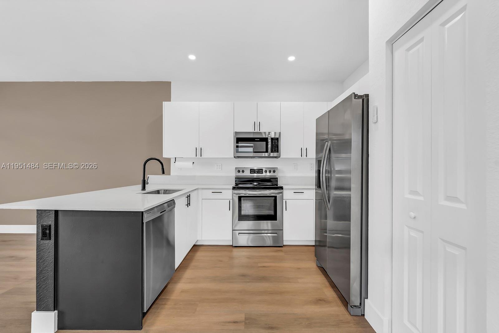 13067 Southwest 286th Street, Unit 13067 Homestead, FL 33033 - Photo 4 of 37 a kitchen with a refrigerator and a sink