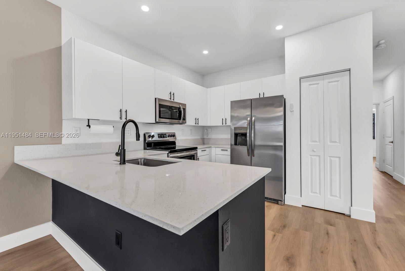 13067 Southwest 286th Street, Unit 13067 Homestead, FL 33033 - Photo 5 of 37 a kitchen with refrigerator cabinets and wooden floor