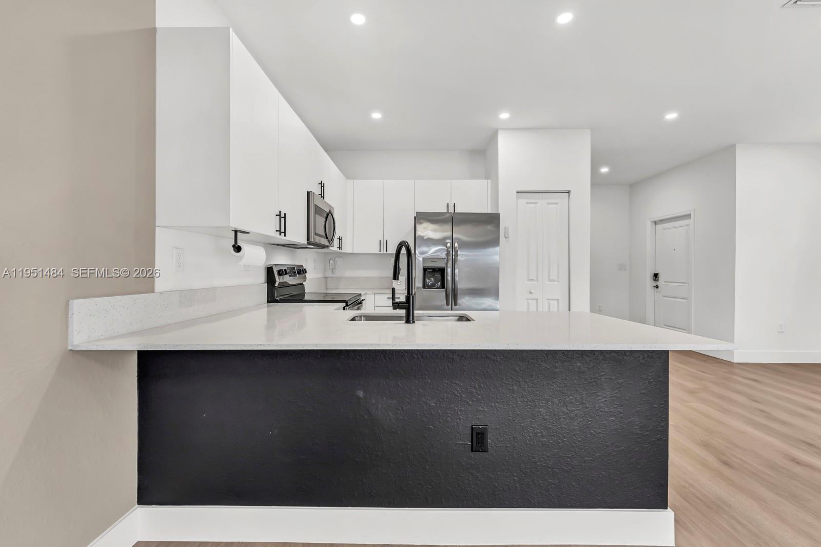 13067 Southwest 286th Street, Unit 13067 Homestead, FL 33033 - Photo 6 of 37 a kitchen with stainless steel appliances a sink stove and cabinets