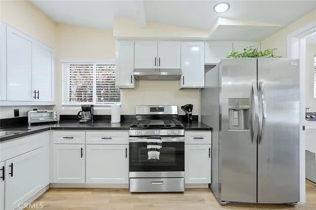 a kitchen with white cabinets and white stainless steel appliances