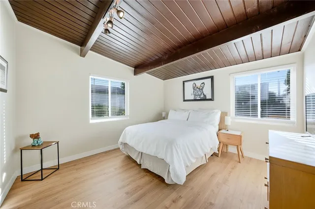 a spacious bedroom with a bed and wooden floor