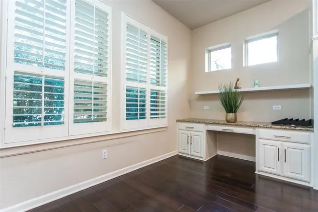 a kitchen with stainless steel appliances white cabinets and a wooden floor