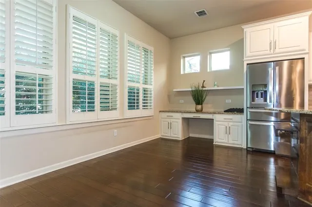 a kitchen with a refrigerator and white cabinets