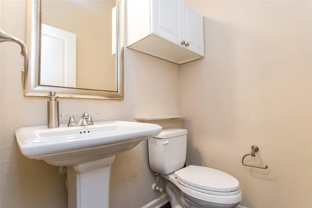 a bathroom with a toilet a sink and mirror
