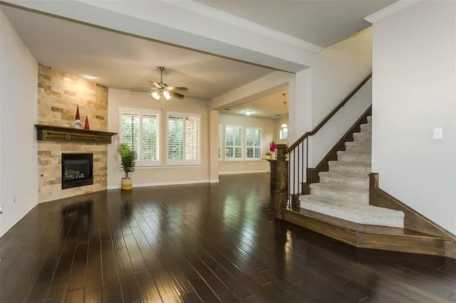 a view of a livingroom with wooden floor a fireplace and windows