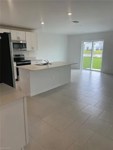 a kitchen with stainless steel appliances a refrigerator and a stove top oven