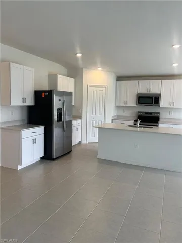 a kitchen with stainless steel appliances a refrigerator sink and microwave