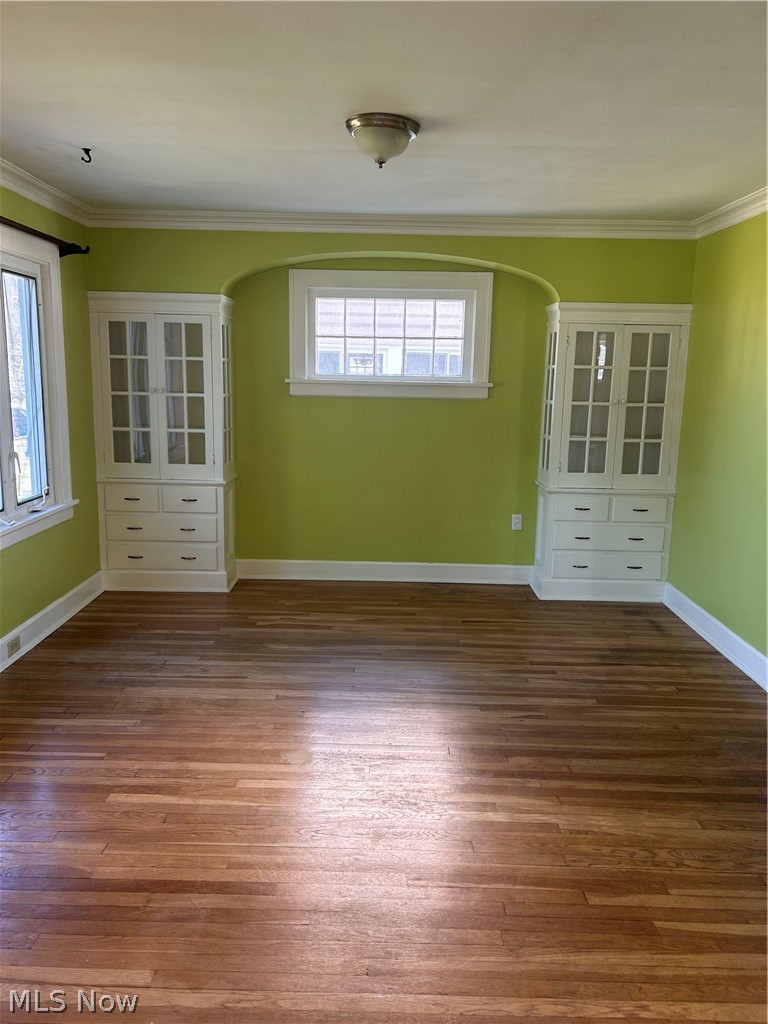 1001 Englewood Road Cleveland Heights, OH 44121 - Photo 5 of 28 Empty room with ornamental molding, dark wood-style floors, and arched walkways