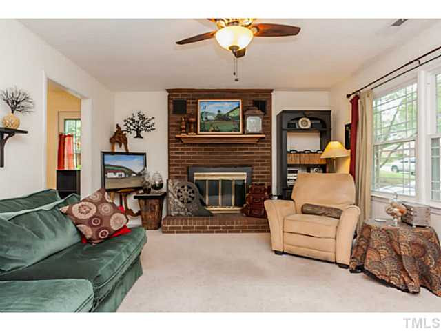 503 Corwin Road Garner, NC 27529 - Photo 3 of 23 a living room with furniture a fireplace and a flat screen tv