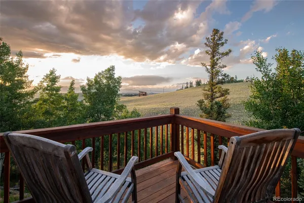 a roof deck with table and chairs