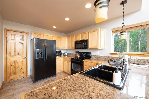 a kitchen with sink refrigerator and window