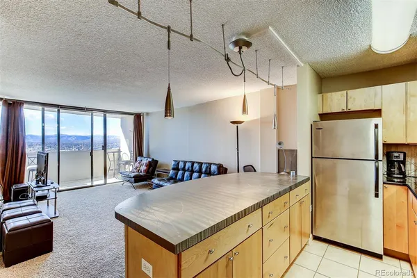 a kitchen with stainless steel appliances a stove a refrigerator a sink and white cabinets with wooden floor