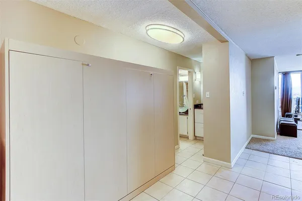 a view of a hallway with closet and a bathroom
