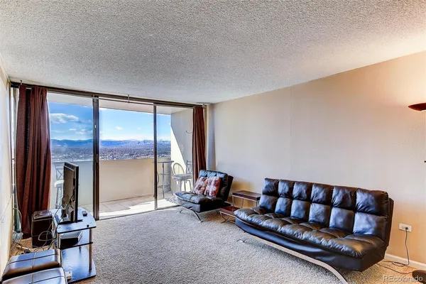 a living room with furniture and a floor to ceiling window