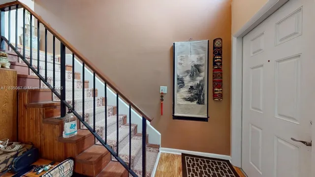 a view of staircase with lots of frames on wall and a window