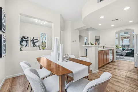 a living room with furniture a wooden floor and a kitchen view