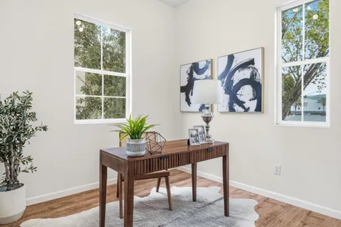 a view of a workspace room with a table and a potted plant