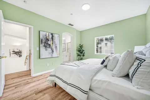 a bedroom with a bed and a painting on the wall