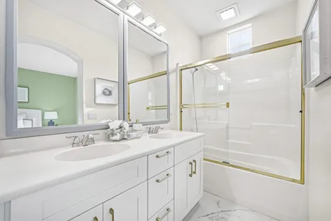 a bathroom with a shower sink vanity and mirror