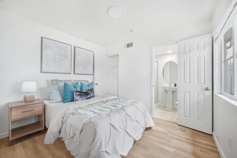 a bedroom with a bed and a painting on the wall