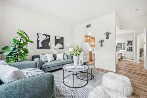 a living room with furniture and wooden floor