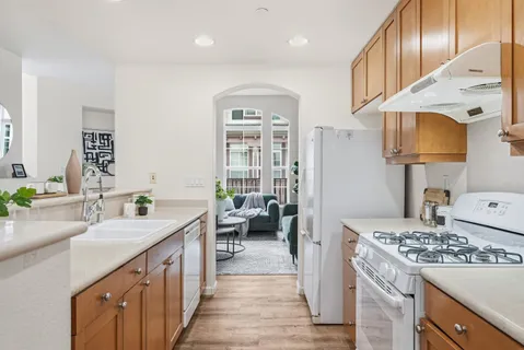 a kitchen with kitchen island granite countertop a sink stove and cabinets