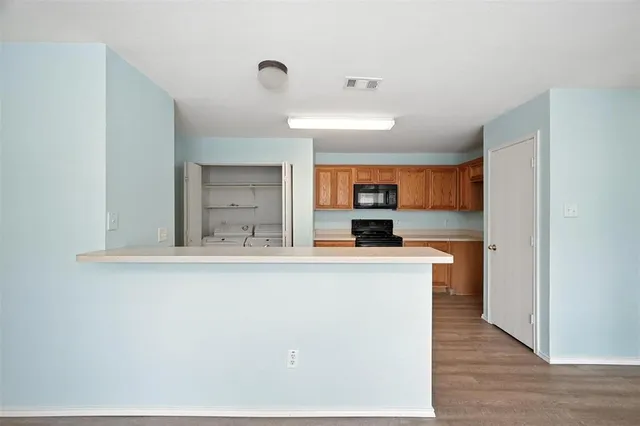 a view of kitchen with stainless steel appliances granite countertop refrigerator sink and stove
