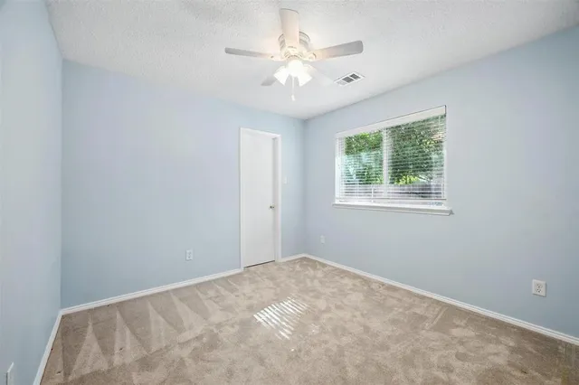 a view of a room with a ceiling fan and a window