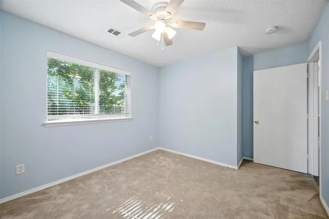 a view of a room with a ceiling fan and a window