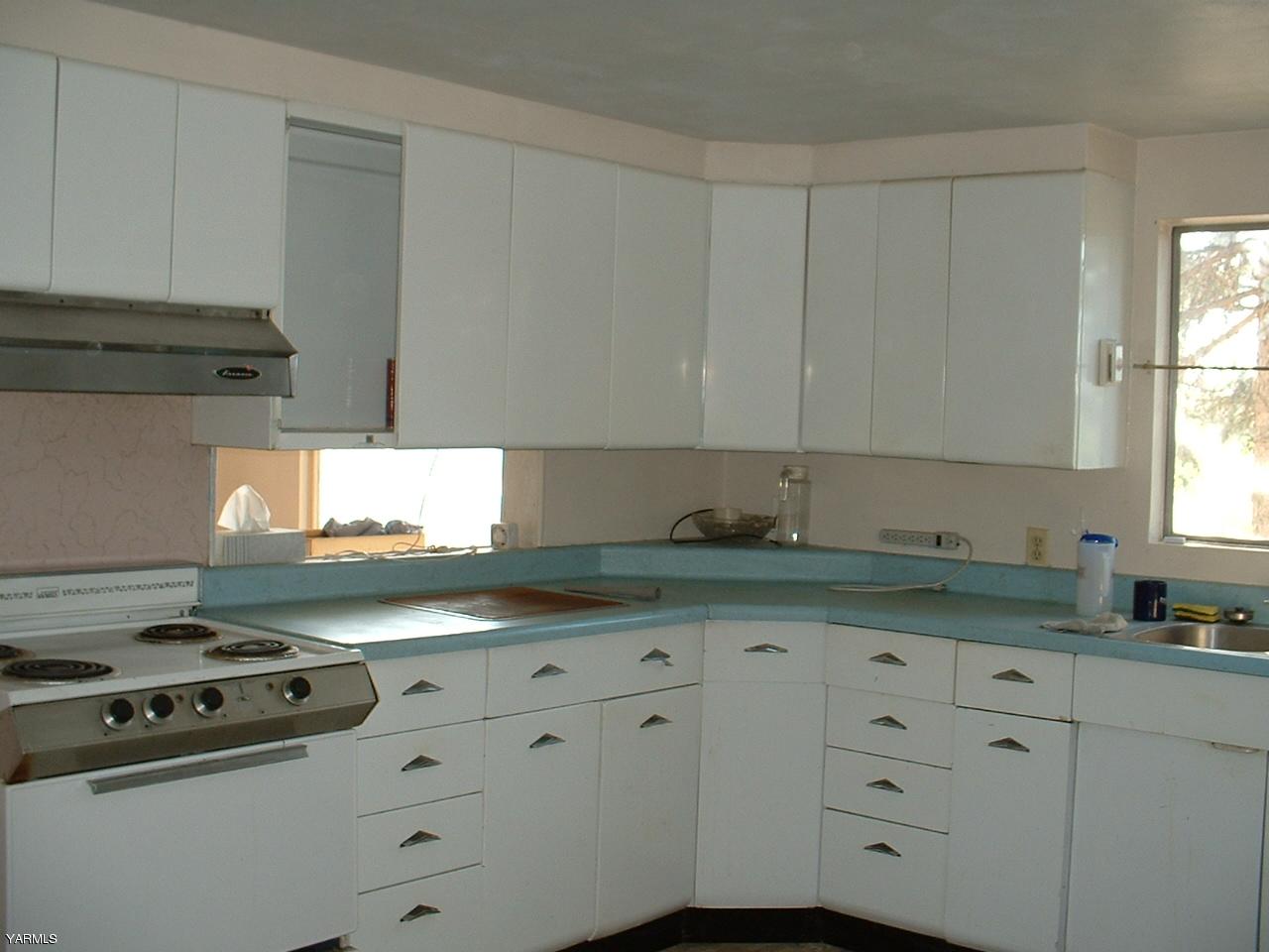 810 North Granger Road Granger, WA 98932 - Photo 2 of 6 a kitchen with granite countertop white cabinets and stainless steel appliances