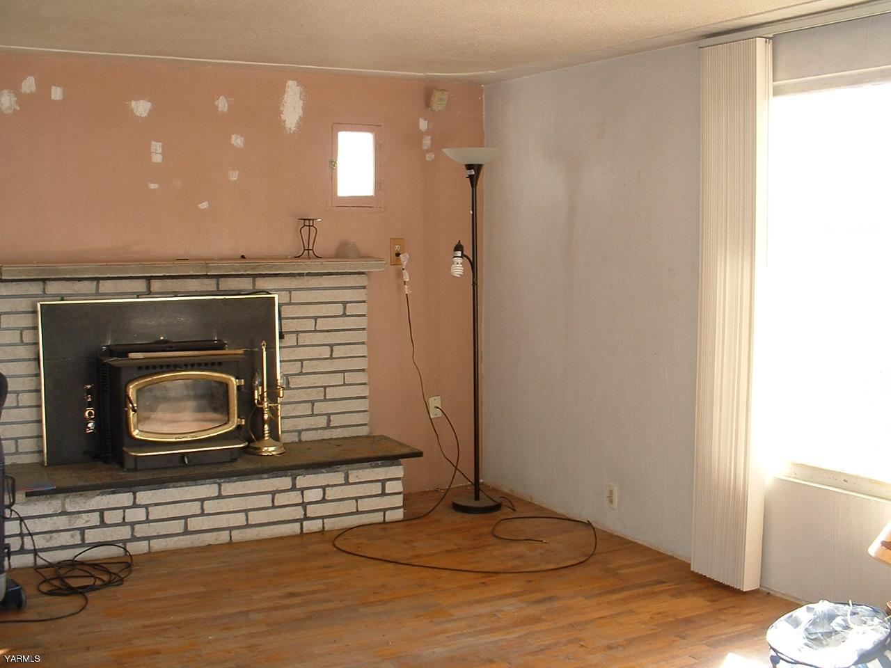 810 North Granger Road Granger, WA 98932 - Photo 5 of 6 a view of a livingroom with wooden floor and a fireplace