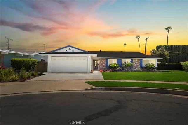 a front view of a house with a garden and plants