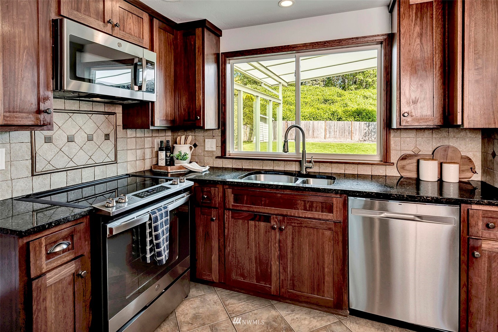 23413 12th Place West Bothell, WA 98021 - Photo 10 of 39 a kitchen with stainless steel appliances granite countertop a stove a sink and a microwave