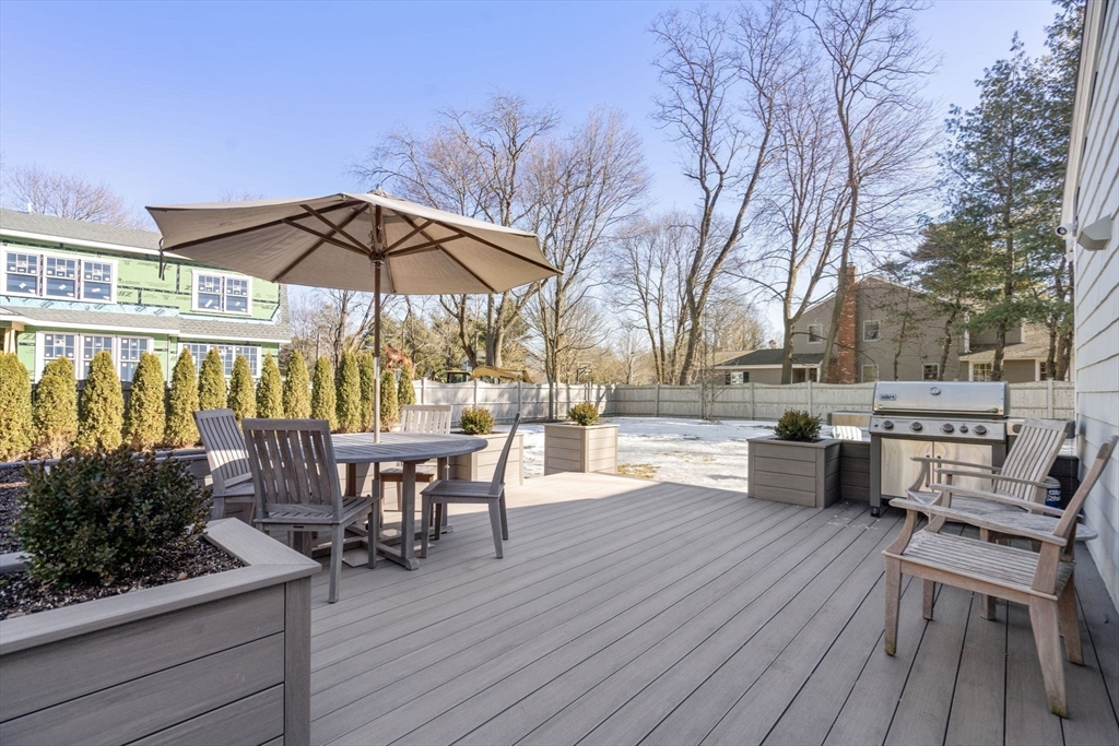4 Stevens Road Wellesley, MA 02482 - Photo 35 of 39 a view of a roof deck with table and chairs under an umbrella with wooden floor