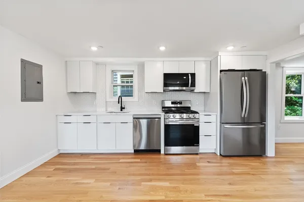 a kitchen with stainless steel appliances a refrigerator a stove top oven a sink and dishwasher