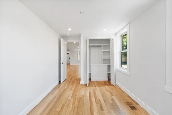 a view of a room with wooden floor and a hallway