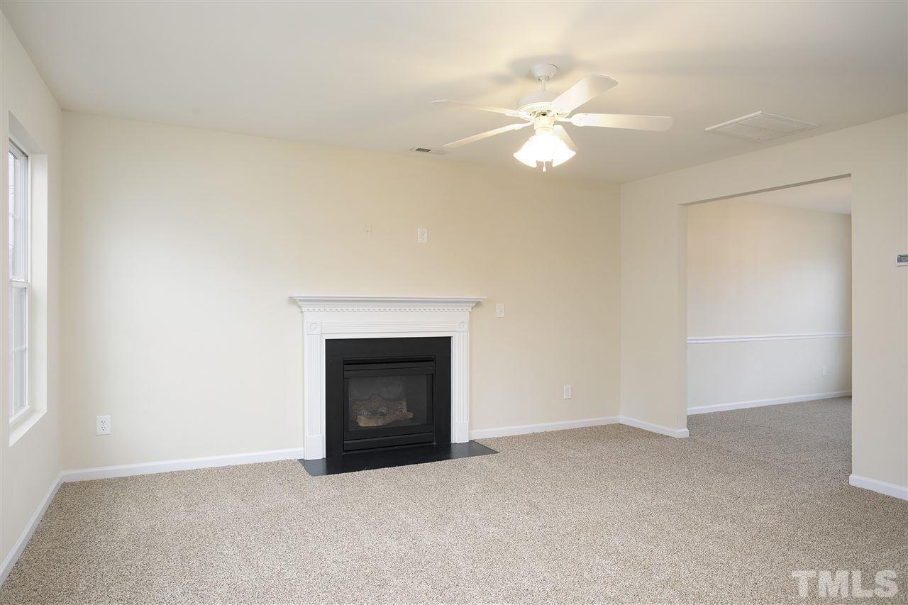 1112 Lombar Street Raleigh, NC 27610 - Photo 2 of 19 an empty room with windows and fireplace