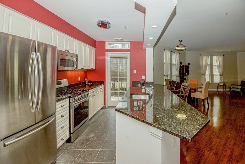 a kitchen with stainless steel appliances granite countertop a refrigerator a oven and a stove