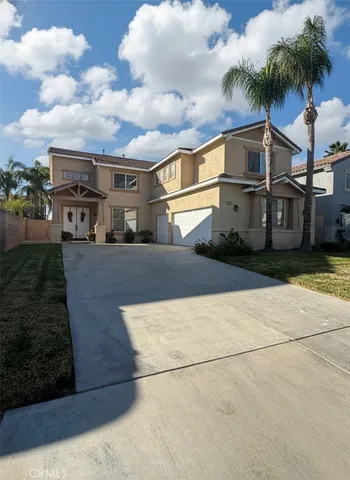 a front view of a house with a yard and potted plants