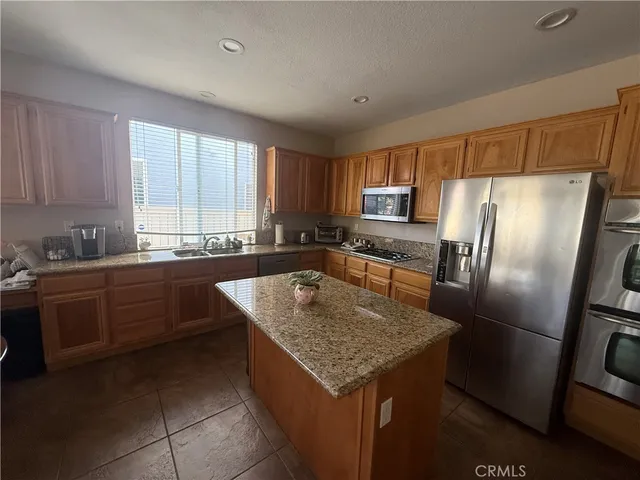 a kitchen with stainless steel appliances granite countertop a sink a stove and a refrigerator