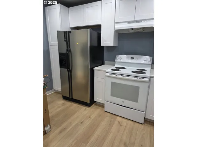 a kitchen with a stove top oven and refrigerator