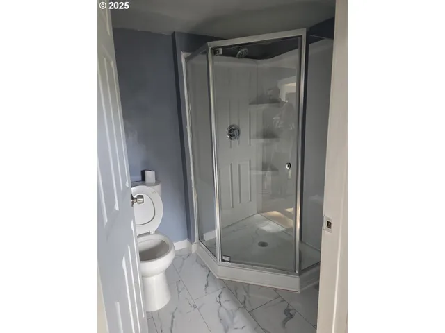 a bathroom with a granite countertop shower a toilet and a sink