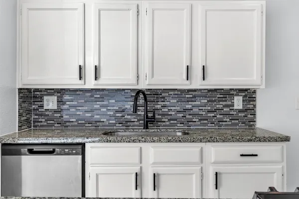 a view of kitchen with granite countertop white cabinets and a granite counter tops