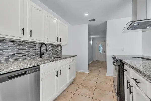 a kitchen with granite countertop a sink and a stove