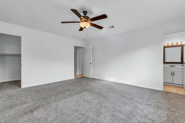 a view of an empty room with a ceiling fan