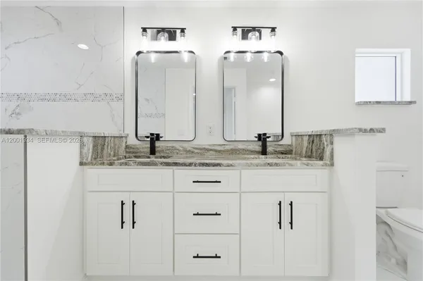 a bathroom with double vanity sinks and a mirror