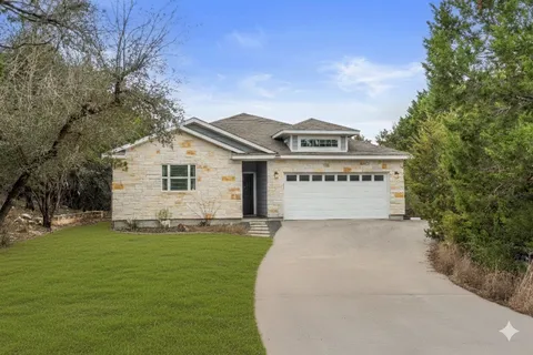 a view of a house with a big yard and large trees