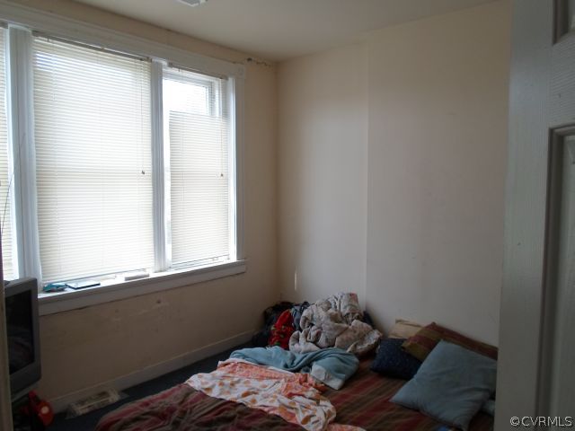 1312 Decatur Street Richmond, VA 23224 - Photo 2 of 7 a bed sitting in a bedroom next to a window